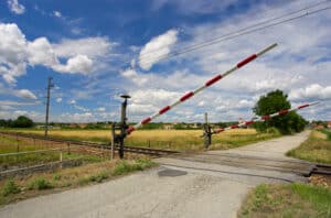 Ein beschrankter Bahnübergang wird durch ein Verkehrszeichen angekündigt.